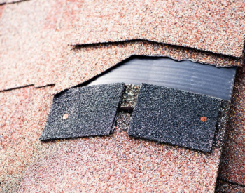 Close-up of damaged shingles on a Poway roof, highlighting the need for repair.